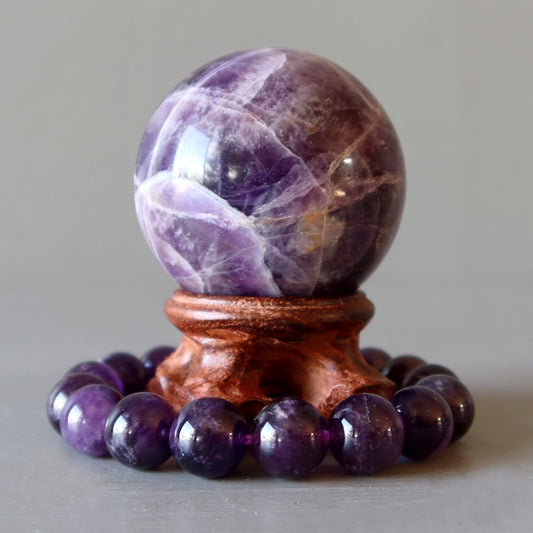 amethyst crystal ball and bracelet on wood stand